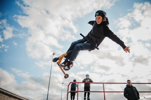 Chlapec skákající ve vzduchu na freestyle koloběžce Rideoo Flyby